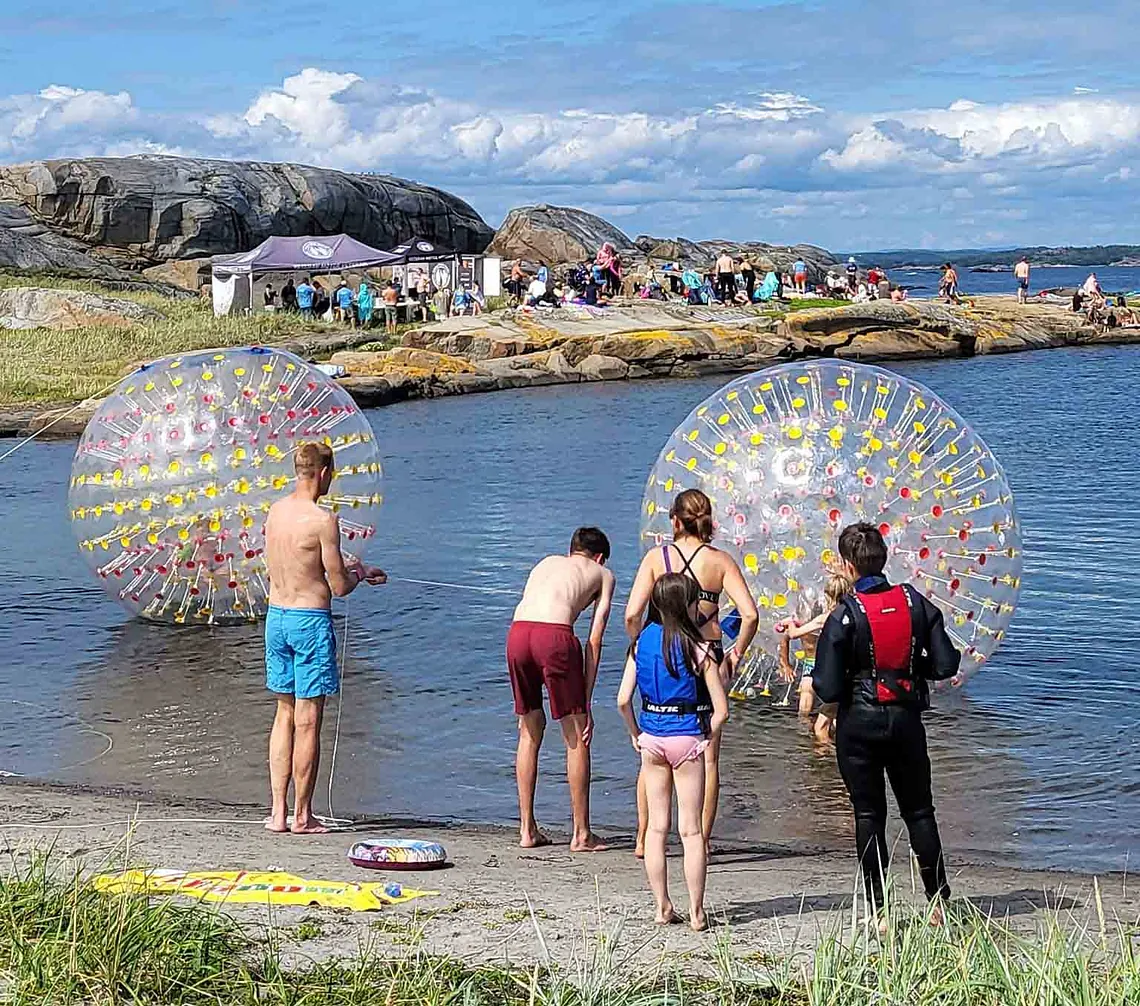 Ungdommer som står på strand og ser utover havet