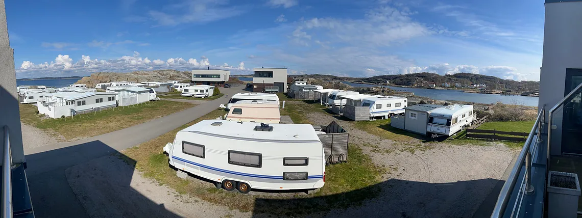 Campingplass med spikertelt, bobiler og campingvogner